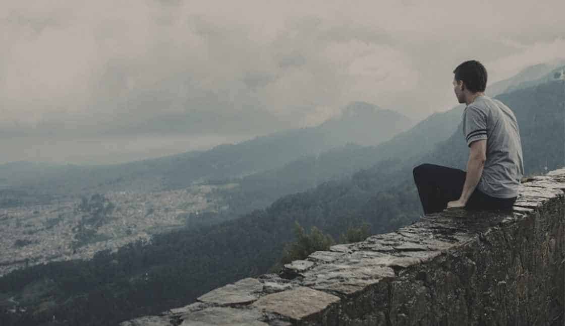 A man sits overlooking the valley and contemplates his online addiction counseling training courses a