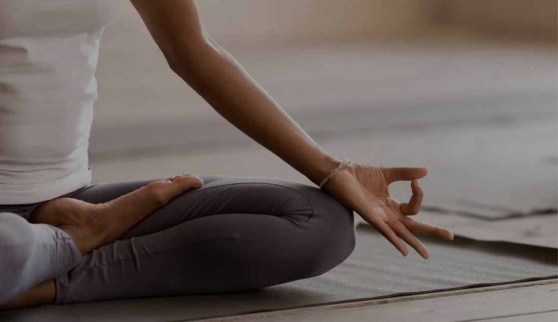 A credentialed CASAC Counselor sits in a yoga study so she can benefit from CASAC counselor wellness. Sher learned this technique in our addiction counselor course