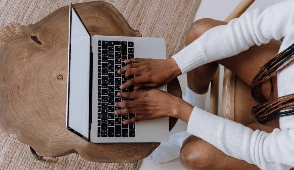 A woman sits at a computer taking a drug screening to determine if she is a drug addict or not.