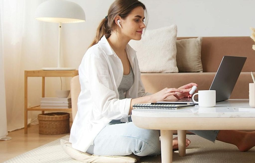 Adult woman studying online for addiction counseling training Florida, taking notes at a desk with a laptop showing course content on counseling techniques and treatment planning.